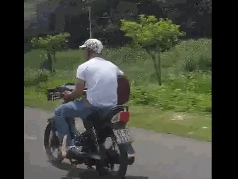 Xác định danh tính nam thanh niên lái xe máy bằng chân, ôm đàn đánh say mê